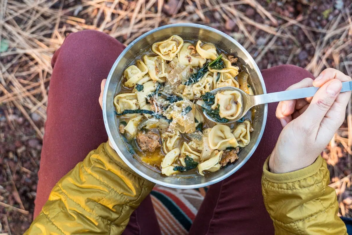 Overhead view of Megan holding a bowl of tortellini soup