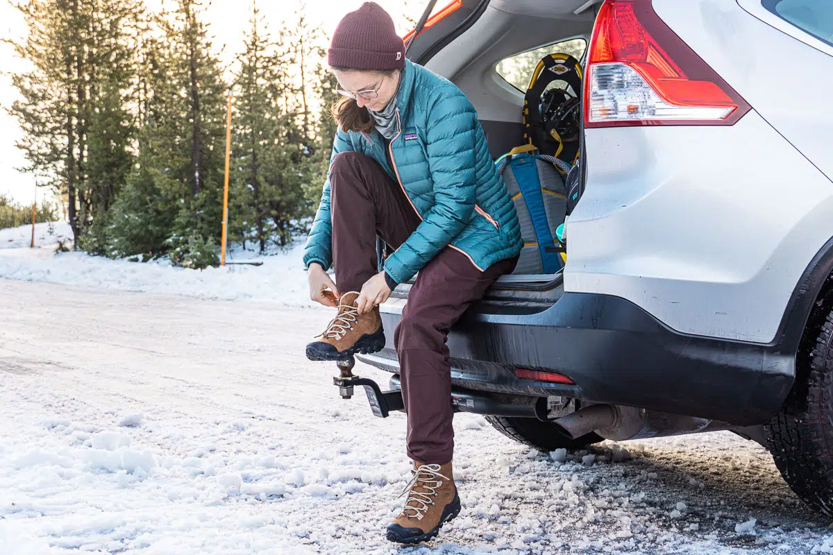 Megan sitting on the tailgate of a car tying her shoes